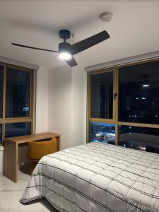 パナマシティにあるMini Design Apartmentのベッドと天井扇風機のある寝室 +2枚の写真
