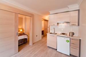 a small kitchen with a bed in a room at Atrium Apart Otel in Altınyunus