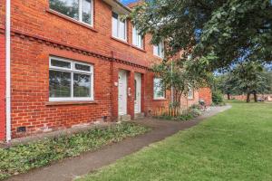 un edificio de ladrillo con una puerta blanca y un patio en 3Bedroom House - Free Parking, en Castleside