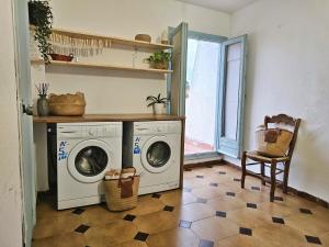 a laundry room with two washing machines and a chair at Nomad Haux in the heart of Tossa 9 in Tossa de Mar