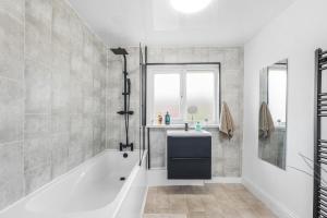 un baño con bañera y lavabo en 3Bedroom House - Free Parking, en Castleside