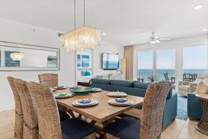 フォート・ウォルトン・ビーチにあるBlu 503 - Luxury Oceanfront - Unbelievable Views - Free Beach Svcのテーブルと椅子のあるダイニングルームとリビングルーム