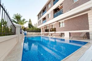 a swimming pool in front of a building at Atrium Apart Otel in Altınyunus