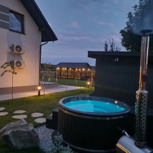 a hot tub in a yard next to a house at Willa Na Białej in Ziajki
