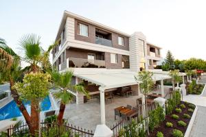 an apartment building with a tennis court in front of it at Atrium Apart Otel in Altınyunus