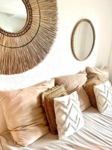 a bedroom with a bed with pillows and a mirror at Domaine des Vignes Golfe de Saint Tropez in Cogolin +70 photos