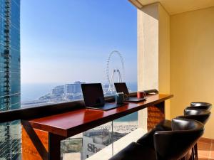 een bureau met twee laptops erop voor een raam bij Simbad Friendly Coliving in Dubai
