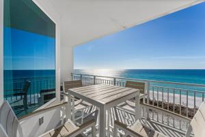 Un balcón con mesa y sillas en la playa. en Blu 603 - Oceanfront Gem - Free Beach Service, en Fort Walton Beach