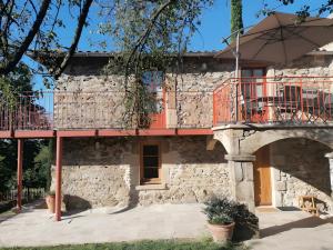 un edificio con balcón y sombrilla en Gite Les Lavoirs, en Crozes-Hermitage