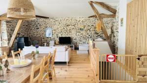 a living room with a table and a stone wall at Le Refuge du Cagire in Aspet