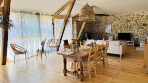 a dining room and living room with a table and chairs at Le Refuge du Cagire in Aspet