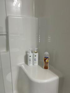 a bathroom with two bottles ofodorizers sitting on a sink at 1BR suite, 20 minutes from the airport, with a kitchen in Edmonton +8 photos