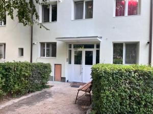 a bench sitting in front of a white building at Premium Apartment Turda in Turda