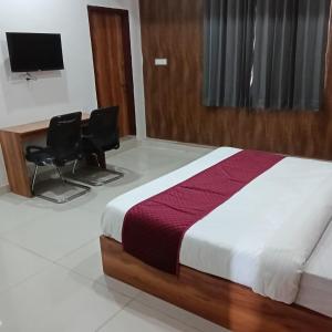 a bedroom with a bed and two chairs at Hotel HAV Jaipur in Jaipur