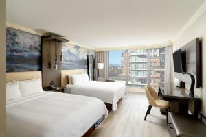 a hotel room with two beds and a desk and a television at Victoria Marriott Inner Harbour in Victoria +36 photos