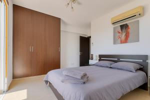 a bedroom with a large bed with towels on it at Sunflight Apt 01B One Bedroom Apt in Larnaca