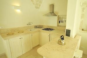 a kitchen with a sink and a stove top oven at Casa Antica Roma in Ostuni