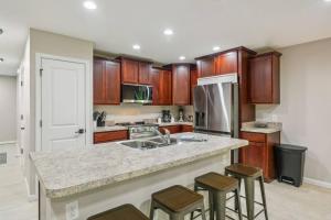 a kitchen with wooden cabinets and a counter with stools at Isabella Ct Townhome in Orange Park