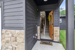 a black house with an orange door and a stone wall at Isabella Ct Townhome in Orange Park