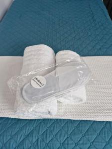 a plastic container on a bed with towels at Georgias house 7 min from Athens airport in Artemida