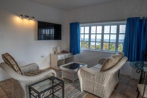 a living room with chairs and a table and a window at Flip-Flops at Sapphire House in Laborie