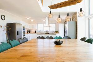 a kitchen and dining room with a large wooden table at Traumvilla am Müritz Nationalpark, 17 Gäste, Sauna in Boek