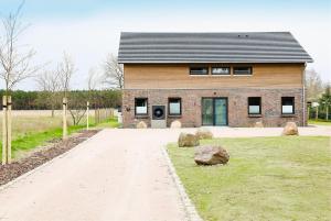 a brick building with a driveway in front of it at Traumvilla am Müritz Nationalpark, 17 Gäste, Sauna in Boek