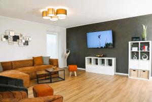 a living room with a couch and a tv on a wall at Traumvilla am Müritz Nationalpark, 17 Gäste, Sauna in Boek