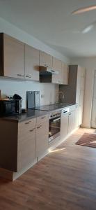 Una cocina con gabinetes blancos y un horno de estufa. en Gemütliches Ferienapartment Für jedes Budget, en Horhausen