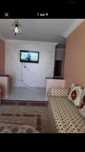 a living room with a couch and a flat screen tv at Hatime zarkaoui in Casablanca