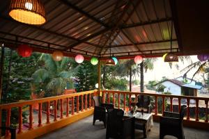 Un restaurante con una mesa y sillas en un balcón. en Koral Islands Homestay, en Sadāshivgarh