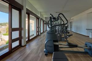 a gym with a treadmill in a room with windows at Hotel do Mar in Sesimbra