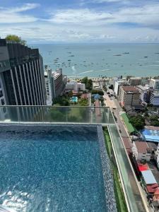 a pool on the roof of a building overlooking the ocean at 芭提雅中心地区 The Base 高档公寓酒店 in Pattaya Central