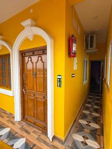 a yellow wall with a wooden door in a house at Lake View Residency in Puducherry