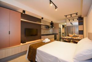 a bedroom with a large white bed and a kitchen at Viva Trindade - CEN009 in Florianópolis +38 photos