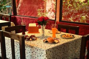 una mesa con platos de comida y un jarrón de rosas en Koral Islands Homestay, en Sadāshivgarh