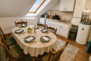a dining room with a table and a kitchen at Joós Apartman in Sárvár