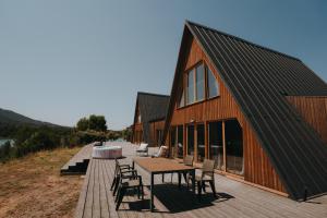 a barn with a table and chairs on a wooden deck at Brisas Lagoon Villas - Cabaña con vistas al lago in Pareja