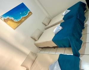a room with two beds with blue sheets at Apartamento Central in Passos