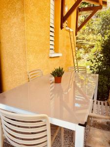 a glass table and chairs on a patio at Gîte Belle Place in Le Gosier