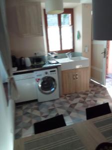 una cucina con lavatrice e lavandino di La bourguignonne a Villemanoche Altre 5 foto