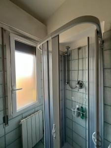 a bathroom with a shower with a window and a glass door at Bellavista panoramic terrace Appartamento con terrazza zona Sant Orsola in Bologna