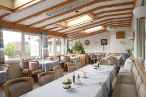 a restaurant with white tables and chairs and windows at Gasthof Kessler in Oberthulba