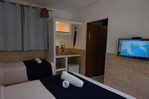 a hotel room with two beds and a flat screen tv at Pousada Pono Village in Juquei