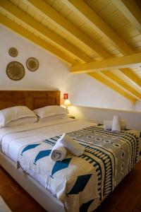 a bedroom with a bed with towels on it at Aldeia da Pedralva - Slow Village in Vila do Bispo +95 photos