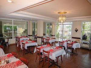 a restaurant with red and white tables and chairs at Boutique Hotel La Cordillera in San Pedro Sula