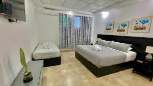a bedroom with a bed and a table and a tv at Hotel Coronado Inn in Playa Coronado