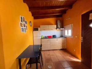 a kitchen with yellow walls and a table and chairs at CASA DIANA in Máguez