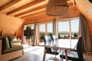 a dining room with a table and chairs and windows at Brisas Lagoon Villas - Cabaña con vistas al lago in Pareja