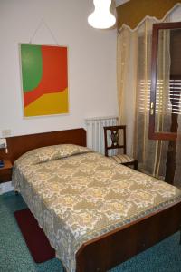 Un dormitorio con una cama y un cuadro en la pared. en Albergo I Longobardi, en Chiusi
